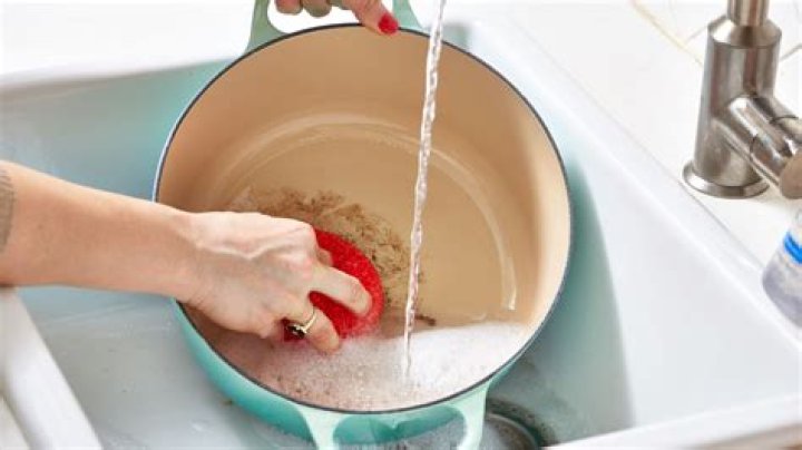 What is the purpose of adding baking soda to soapy water when washing dishes?